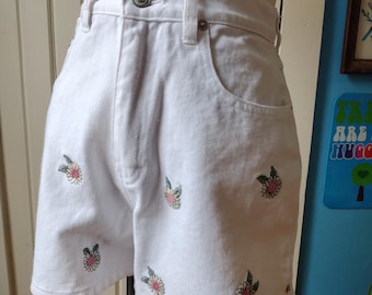 May include: White denim shorts with embroidered flowers in pink, green, and yellow.