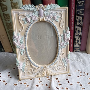 Cornice portafoto decorativa vintage beige rosa verde con motivo floreale a foglie e volute, ovale, piccola e raffinata.