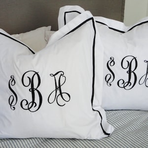 May include: Two white pillowcases with black piping and black embroidered initials "SBH" on each pillowcase.