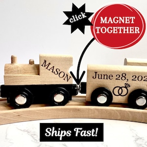 May include: Wooden toy train with black wheels and the name "MASON" on the engine. The second car has "June 28, 2027" and wedding rings. The text "MAGNET TOGETHER" is in a red circle. The text "Ships Fast!" is in a black rectangle.