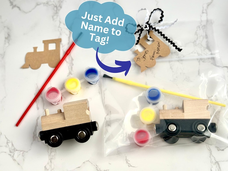 May include: Wooden train craft kit with paint and brushes. The kit includes a wooden train, paint pots in red, yellow, and blue, and a tag that says "Just Add Name to Tag!"
