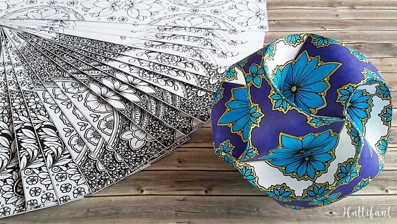 May include: A set of 18 black and white mandala coloring pages with a blue, white, and gold geometric paper sphere with a floral pattern.
