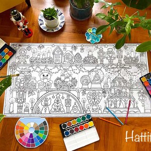May include: A large coloring page featuring a Christmas scene with a gingerbread house, a nutcracker, a snow globe, and a Christmas tree. The page is surrounded by paint palettes and brushes, suggesting it is ready for coloring.