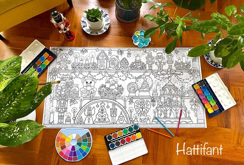 May include: A large coloring page featuring a Christmas scene with a gingerbread house, a nutcracker, a snow globe, and a Christmas tree. The page is surrounded by paint palettes and brushes, suggesting it is ready for coloring.