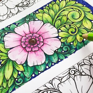 Pode incluir: Marcador floral parcialmente colorido com uma flor rosa e folhas verdes. O marcador est&aacute; sendo colorido com um l&aacute;pis de cor verde. A palavra "Hattifant" &eacute; vis&iacute;vel no canto inferior esquerdo.