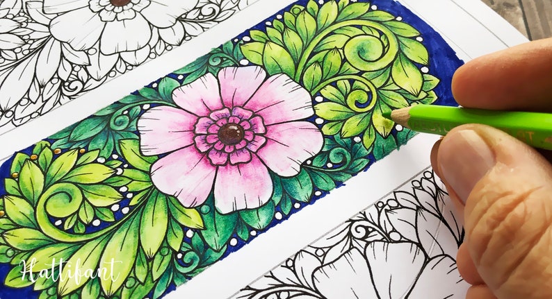 Pode incluir: Marcador floral parcialmente colorido com uma flor rosa e folhas verdes. O marcador est&aacute; sendo colorido com um l&aacute;pis de cor verde. A palavra "Hattifant" &eacute; vis&iacute;vel no canto inferior esquerdo.