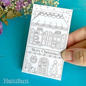 May include: A black and white coloring page featuring a gingerbread house with a snowman, cat, and Christmas tree. The text "Merry Christmas!" is written on the house.