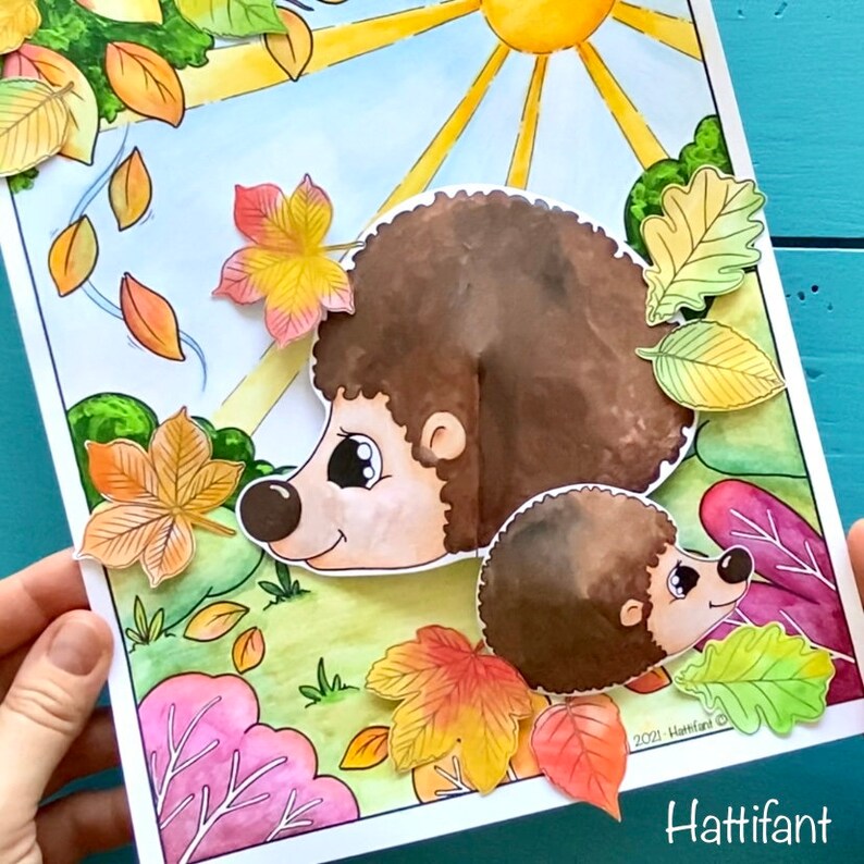 May include: A printable craft activity featuring two hedgehogs with brown fur and large eyes. The hedgehogs are surrounded by colorful fall leaves in shades of red, orange, yellow, and green. The text "Hattifant" is visible at the bottom of the image.