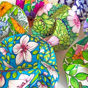 Pode incluir: Close-up de v&aacute;rias pe&ccedil;as de arte em papel, cada uma intrincadamente decorada com desenhos florais. As pe&ccedil;as apresentam uma variedade de cores, incluindo azul, rosa, laranja e verde, com ilustra&ccedil;&otilde;es detalhadas de flores e folhas. O tema geral &eacute; natureza e arte.