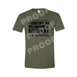 May include: A green t-shirt with a black graphic that says "I identify as non-bidenary. My pronouns are fjb/lgbt."