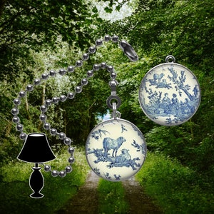 May include: A silver chain light pull with a blue and white porcelain pendant featuring a pastoral scene with sheep. The pendant is round and has a white background with blue details.