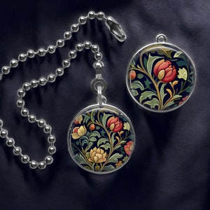 May include: Two round, silver fan pull chains with floral designs. The designs feature red, yellow, and green flowers on a dark blue background.