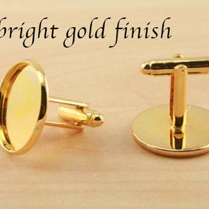 May include: A pair of gold cufflinks with a round, smooth, gold-toned surface. The cufflinks have a bright gold finish.