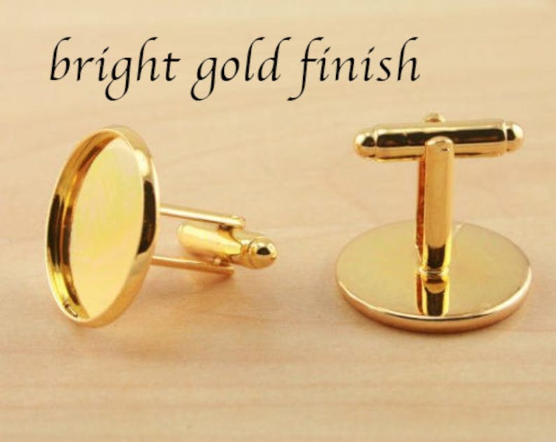 May include: A pair of gold cufflinks with a round, smooth, gold-toned surface. The cufflinks have a bright gold finish.