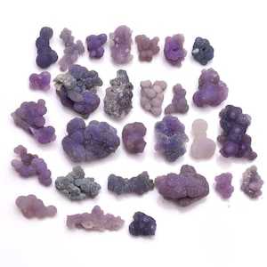 May include: A collection of 25 purple agate geodes, also known as septarian nodules, with a variety of shapes and sizes. The geodes are a natural formation with a unique, bubbly texture.