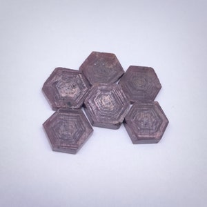 May include: A group of six hexagonal purple gemstones with a striated pattern. The gemstones are arranged in a cluster.
