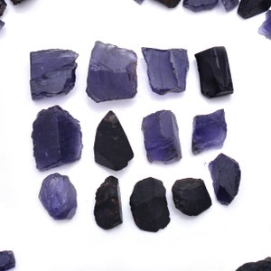 以下が含まれることがあります： 紫と黒の宝石のコレクション。宝石は様々な形とサイズです。