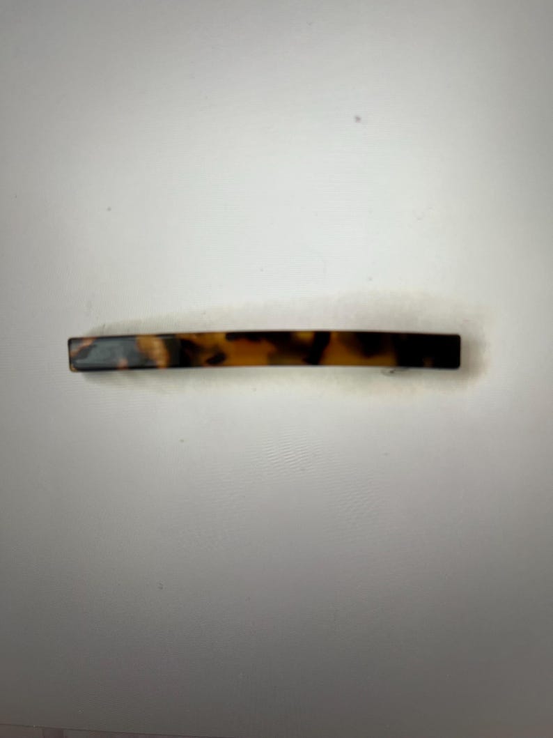 May include: A brown and black tortoiseshell hair clip.