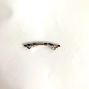 May include: A tortoiseshell hair clip with a silver metal clasp.