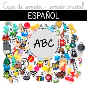 Puede incluir: Una colección de amuletos y baratijas coloridas con el tema del alfabeto, incluyendo un arcoíris, un búho y un diamante. La palabra "ABC" está en el centro, con la palabra "ESPAÑOL" arriba. Varios objetos pequeños y detallados están dispersos.