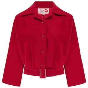 May include: A bright red cropped jacket with a wide collar, three buttons, and a matching belt with a rectangular buckle. The jacket has three-quarter sleeves and a label with text and a lipstick kiss.