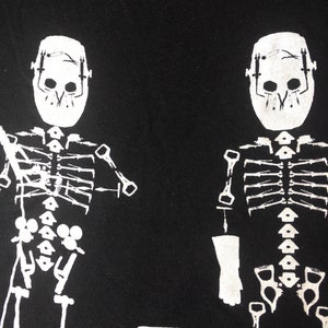 May include: Two white skeleton figures with masks on a black background. The skeletons are wearing a mask over their skulls and have a rib cage and bones visible.