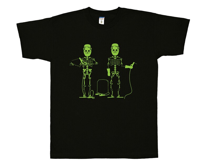May include: A black short-sleeve t-shirt featuring a bright lime green graphic print of two skeletons wearing welding masks. One skeleton holds a welding torch while the other holds a welding rod, with a rectangular welding tank positioned between them.