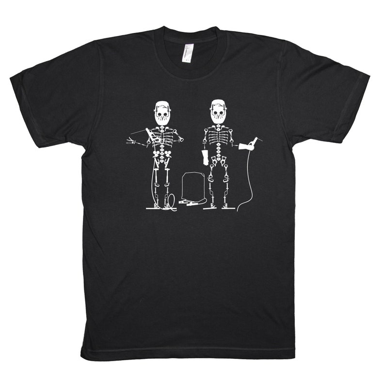 May include: Black t-shirt with a white graphic of two skeletons wearing welding masks and holding welding tools.