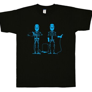 May include: A black short-sleeve t-shirt featuring a bright blue graphic print of two skeletons wearing welding helmets and holding welding equipment, with a small rectangular welding machine positioned between them on the chest area.