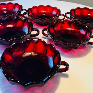May include: Set of six ruby red glass bowls with scalloped edges and two handles. The bowls are perfect for serving desserts, appetizers, or snacks.