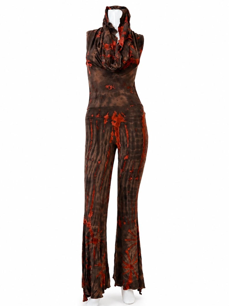 May include: A sleeveless jumpsuit featuring a cowl neckline and flared pant legs. The garment is colored in a dark brown and vibrant orange tie-dye pattern that creates a vertical, streaked effect across the entire length of the piece.