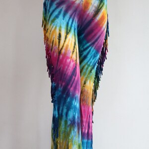 May include: Tie-dye pants with fringe detail. The pants are a mix of blue, purple, pink, yellow, and green.