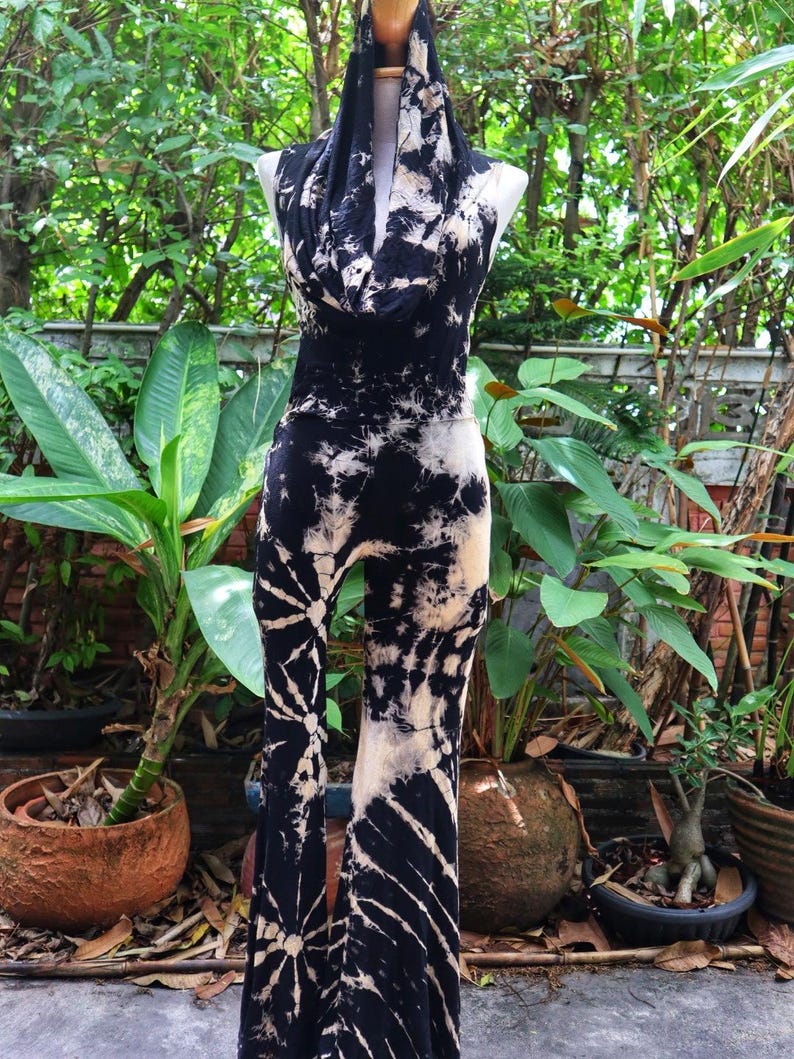 Puede incluir: Un mono de color negro y blanco con estampado tie-dye, cuello de pico y pantalones acampanados. El mono est&aacute; hecho de un tejido suave y el&aacute;stico, perfecto para un look casual y bohemio.