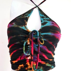 May include: A black halter top with a tie-front detail. The top is made of a stretchy fabric and features a tie-dye pattern in shades of blue, green, orange, red, and purple.