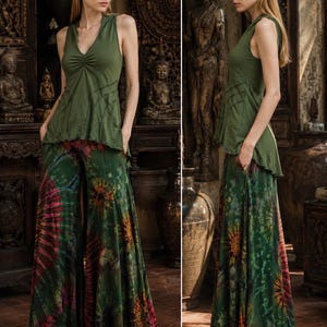 Può includere: Un top senza maniche verde oliva con scollo a V e dettaglio arricciato al centro, abbinato a pantaloni a gamba larga con un motivo tie-dye multicolore nelle tonalità del verde, arancione e rosa con una silhouette fluida fino a terra.