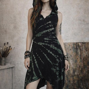 Könnte beinhalten: Schwarzes Kapuzenkleid mit Batikmuster und V-Ausschnitt. Das Kleid hat grüne Akzente und ein ärmelloses Design. Das Model trägt mehrere Armbänder. Das Kleid ist für Freizeitkleidung geeignet.