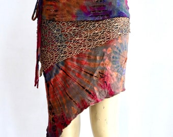 Peut inclure: Une jupe en tie-dye avec un motif brun, rouge et bleu. La jupe a un design superposé avec un panneau en maille et un ourlet effiloché.
