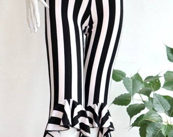 May include: Black and white striped pants with a ruffled hem. The pants are cropped and have a wide leg.