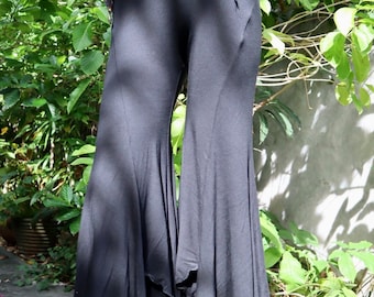 May include: Black wide-leg pants with a flowing, asymmetrical hemline. The pants are made of a soft, stretchy fabric and have a comfortable fit.