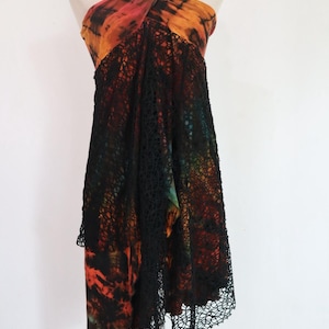 May include: A black and orange tie-dye halter dress with a black crochet overlay. The dress has a long, asymmetrical hemline.