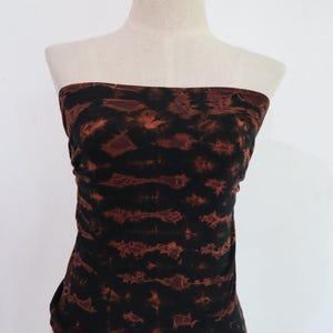 Könnte beinhalten: Ein trägerloses Oberteil mit einem braunen und schwarzen Batik-Muster.
