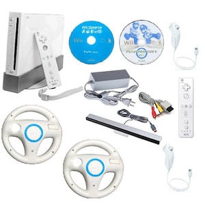 May include: A white Nintendo Wii console with a matching remote and sensor bar. Includes two game discs, two steering wheels, and a power adapter. The console and accessories are arranged on a white background.