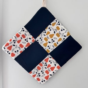 May include: A square pot holder with a checkered pattern. The squares are made of different fabrics with a pear and cherry print. The pot holder is navy blue, white, orange, and yellow.