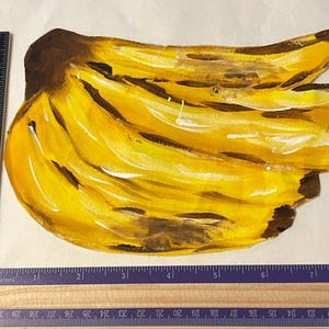 Puede incluir: Un recorte pintado a mano de un racimo de plátanos amarillos con manchas marrones, colocado junto a una regla de madera que muestra una longitud de unos 28 cm y una anchura de unos 18 cm para la ilustración de la fruta.