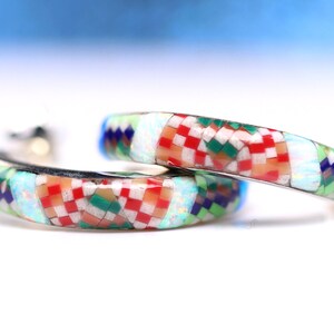 Puede incluir: Un par de pendientes de aro de plata con un diseño de mosaico colorido. El mosaico presenta cuadrados y rectángulos rojos, blancos, verdes, azules y naranjas. Los pendientes están hechos de plata de ley y tienen un diámetro de aproximadamente 2,5 cm.