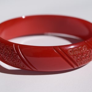 bakelite bracelet red carved bangle diagonal lines and tiny circles intricate design!  Rare Mid Century Collectible jewelry