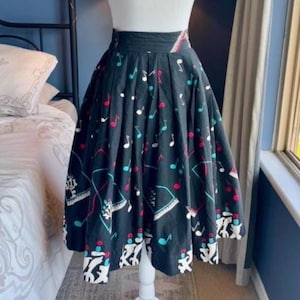 May include: A black midi skirt with a high waist and a full, pleated silhouette. The skirt features a musical theme with colorful musical notes and piano keys. The hemline has a white and black pattern.