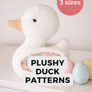 Può includere: Un'anatra di peluche bianca con becco color pesca e interno a fantasia floreale. Il testo "PLUSHY DUCK PATTERNS" è visualizzato sotto. Tre uova dai colori pastello sono accanto all'anatra. Il testo "3 sizes" è in un cerchio rosso.