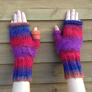Puede incluir: Un par de guantes sin dedos con un degradado de morado, rojo y naranja.