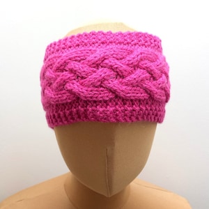 Peut inclure: Un bandeau en tricot rose avec un motif tressé.